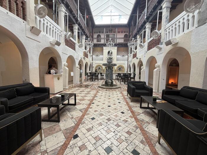 Historic colonnaded courtyard with central fountain and marble statuary