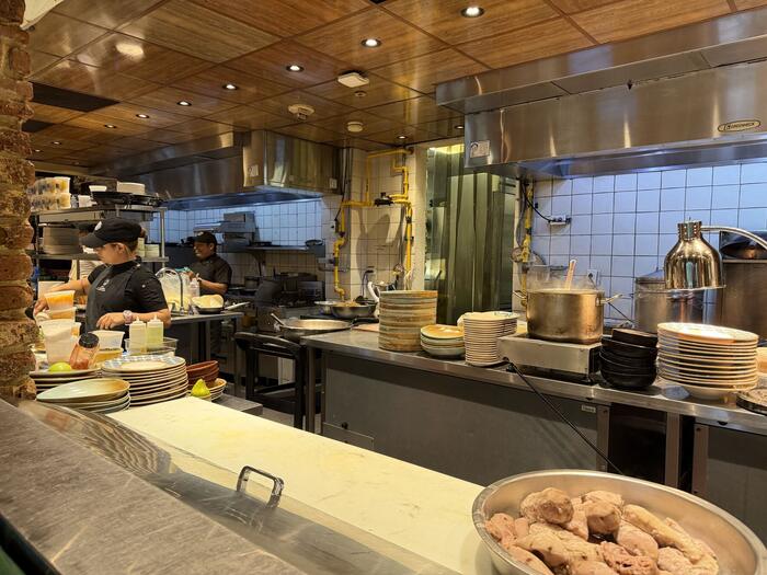 Professional kitchen with chefs preparing plates during service