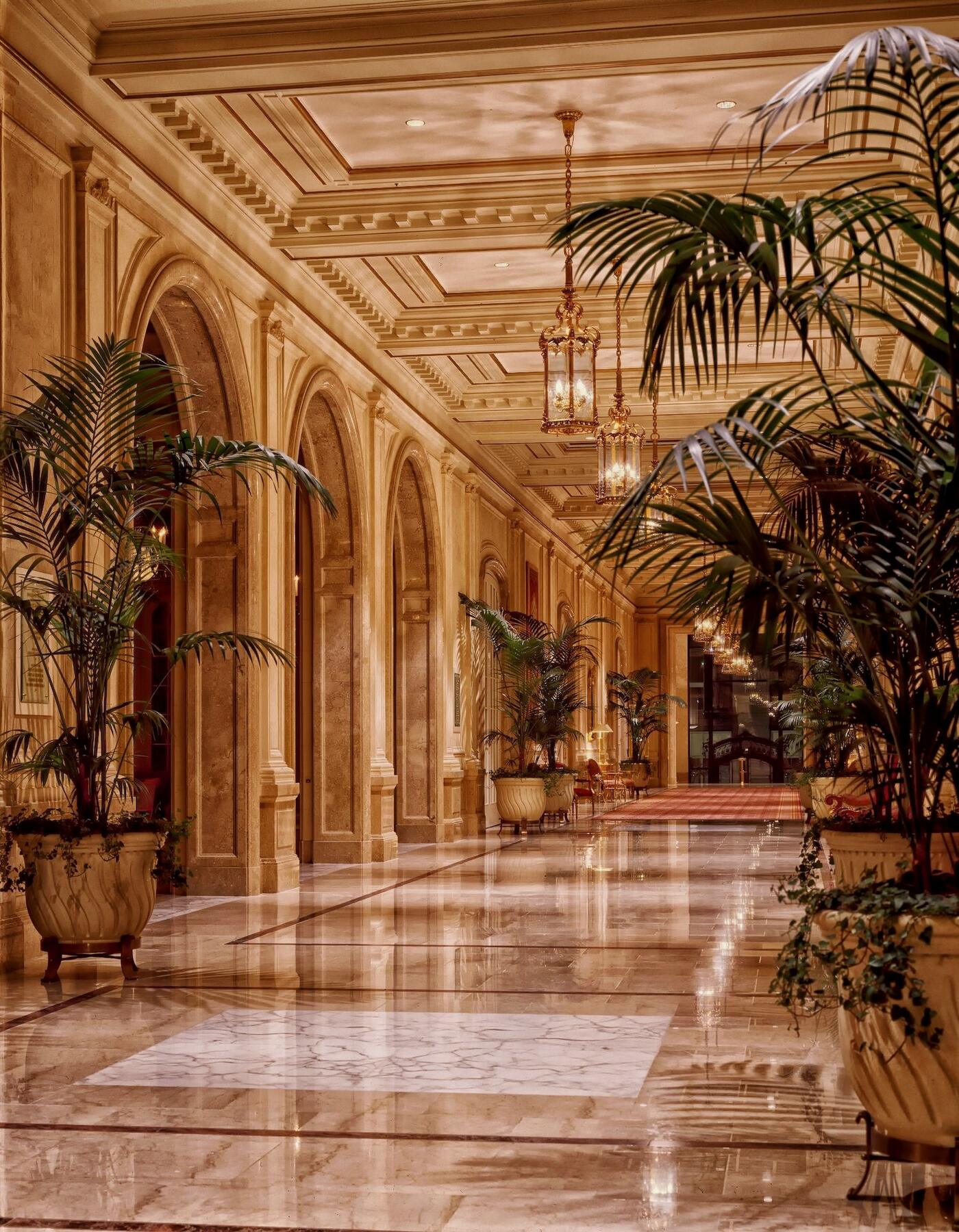 An elegant marble hotel corridor bathed in warm light